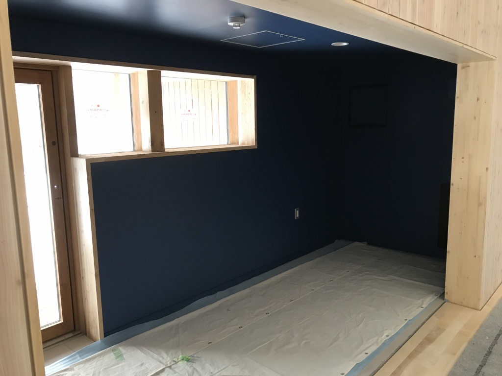青い壁が印象的なペレットストーブのお部屋の画像